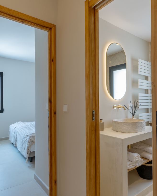 Doorkijk vanuit de gang naar de slaapkamer en de badkamer, met oude paneeldeuren